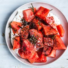 a white plate topped with sliced up watermelon and seasoning on top of it