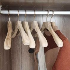 wooden clothes hangers are hanging on a rail