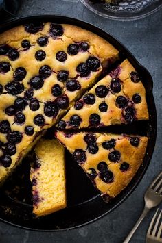 a cake with blueberries is cut into slices