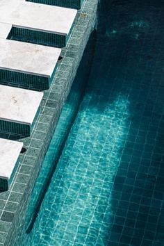 an empty swimming pool with steps leading up to the water's edge and clear blue water