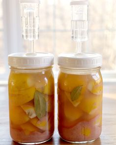 two jars filled with food sitting on top of a wooden table