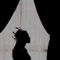 the silhouette of a woman standing in front of a curtain with her hair pulled back