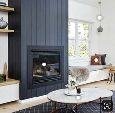 a living room filled with furniture and a fire place in the middle of the room