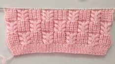 a pink knitted object is shown on a white surface