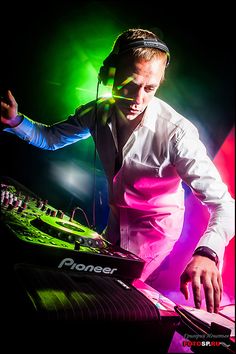 a man in headphones mixing music on a dj's turntable at a concert