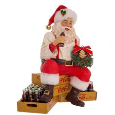 a santa clause statue sitting on top of a crate filled with coca - cola bottles