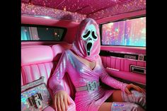 a woman in a pink dress and mask sitting in the back of a car