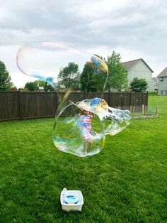 a girl is playing with bubbles in the yard