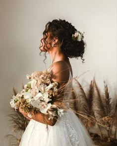 a woman in a wedding dress holding flowers