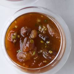 two bowls filled with soup on top of a white table