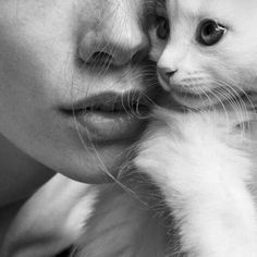 a black and white photo of a woman holding a cat in her arms with the caption, i am not sure what this image is