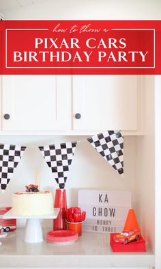 a birthday party with cars and race flags on the counter top, including a cake