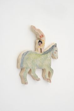 two small ceramic horses on a white wall