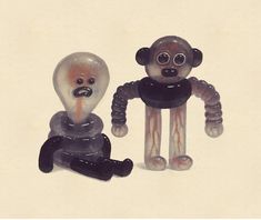 two glass figurines sitting next to each other on a white surface, one is wearing a black shirt and the other has an orange nose