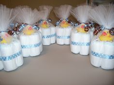 baby shower decorations made to look like diapers with rubber ducks in them and bows on their heads