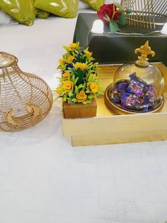 decorative items displayed on white table cloth with yellow and red flowers in glass vases