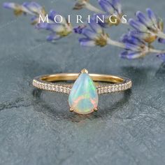 a white opal and diamond ring with the words mohriings on it's side