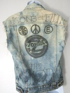 Vintage Levi's Distressed British Punk Jean Vest!We believe that this was a Levi Strauss jacket from the 1980s (70507-0227) that's been cut and marked up celebrating late 70s (1977-1979) punk bands with the following phrases: The Zoundz, The Cravats, Icons of Filth, The Mob. Really quite a work of art.   Men's XS Extra Small - Deep Blue Marbled Denim Measurements: 23" top to bottom :: 19" pit to pit :: 18" shoulder to shoulder :: Condition::Thrashed, distressed, torn and marked up with marker. T Cotton Grunge Vest For Concerts, Grunge Graphic Print Vest For Streetwear, Distressed Cotton Denim Jacket For Festival, Distressed Denim Vest For Streetwear In Grunge Style, Vintage Distressed Denim Vest For Spring, Distressed Grunge Denim Jacket For Festival, Vintage Cotton Denim Vest For Festivals, Grunge Denim Vest For Streetwear, Cotton Grunge Denim Vest For Streetwear