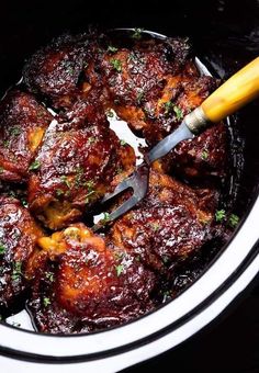 the meat is being cooked in the crock pot with a spatula on top