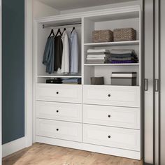 an open closet with white drawers and clothes