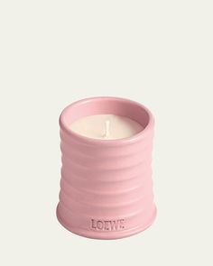 a pink candle holder with the word love written on it and a lit candle inside