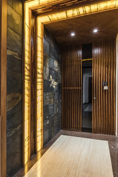 an open door leading into a room with stone walls and wood paneling on the sides