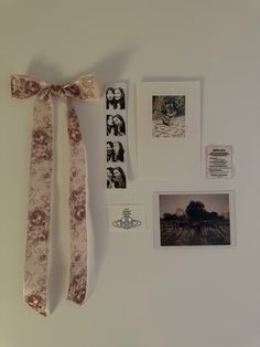 a white wall with pictures on it and a bow tie hanging from the wall next to it