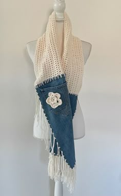 a mannequin wearing a white knitted scarf with a teddy bear on it