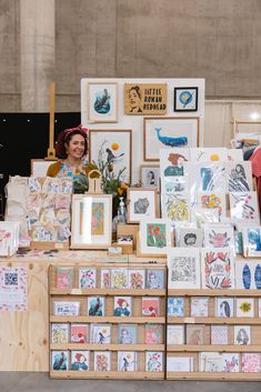 a woman standing in front of a table filled with pictures and greeting cards on it