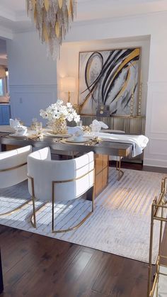 a dining room table with white chairs and chandelier