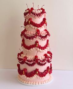 a three tiered cake with red and white decorations