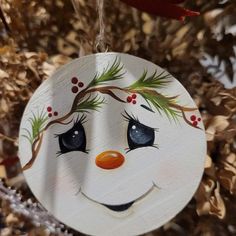 a wooden ornament with a snowman face painted on it's face