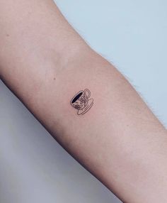 a person's arm with a tattoo on it that has a coffee cup in the middle