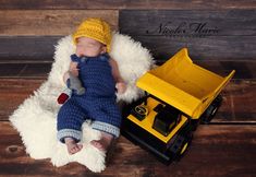 a newborn baby wearing a yellow hat and blue overalls