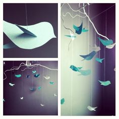 three pictures of paper birds hanging from the ceiling, and one is blue with white origami on it