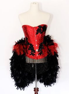 a red and black corset with feathers on it