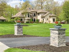 a large house in the middle of a lush green field