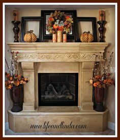 a fire place with some vases on top of it and pictures above the fireplace