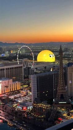 the sun is setting over las vegas and it's ferris wheel in the background