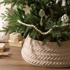 a small christmas tree in a basket on the floor next to other ornaments and decorations