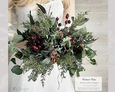 a woman wearing a white dress holding a bouquet of greenery and berries in her hands