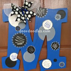 the letter m is made out of cardboard and decorated with black, white and blue decorations