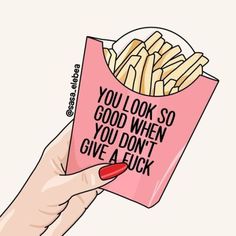 a hand holding a pink paper bag with french fries in it that says, you look so good when you don't give a luck