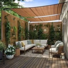 an outdoor living area with couches, tables and potted plants on the deck