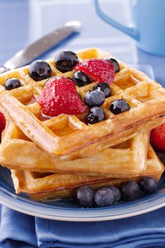 a stack of waffles topped with berries and blueberries