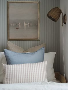 a bed with pillows and a painting on the wall