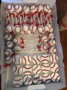 a box filled with lots of white and red baseball cupcakes