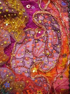 an abstract painting with many different colors and designs on it's fabric, including beads