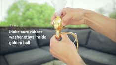 a person holding a brass trumpet in their hand with the words, make sure rubber washer stays inside golden ball