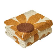 three towels stacked on top of each other in front of a white background with an orange flower